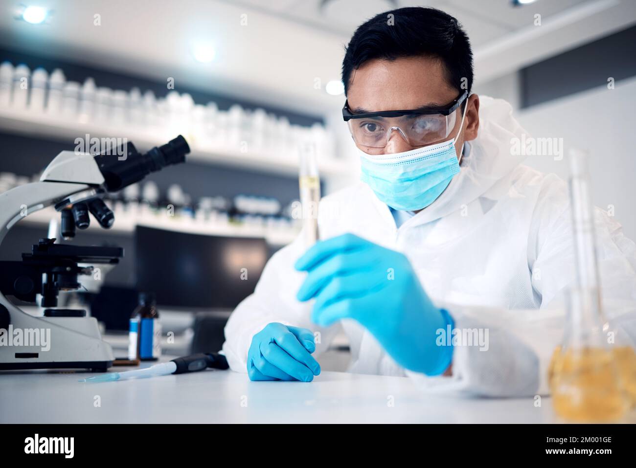 Wissenschaftler, Forschung und Mensch arbeiten im Labor für wissenschaftliche Innovation in Chemie oder Physik, Mikroskop und Reagenzgläser für wissenschaftliche Experimente. Gesichtsmaske Stockfoto