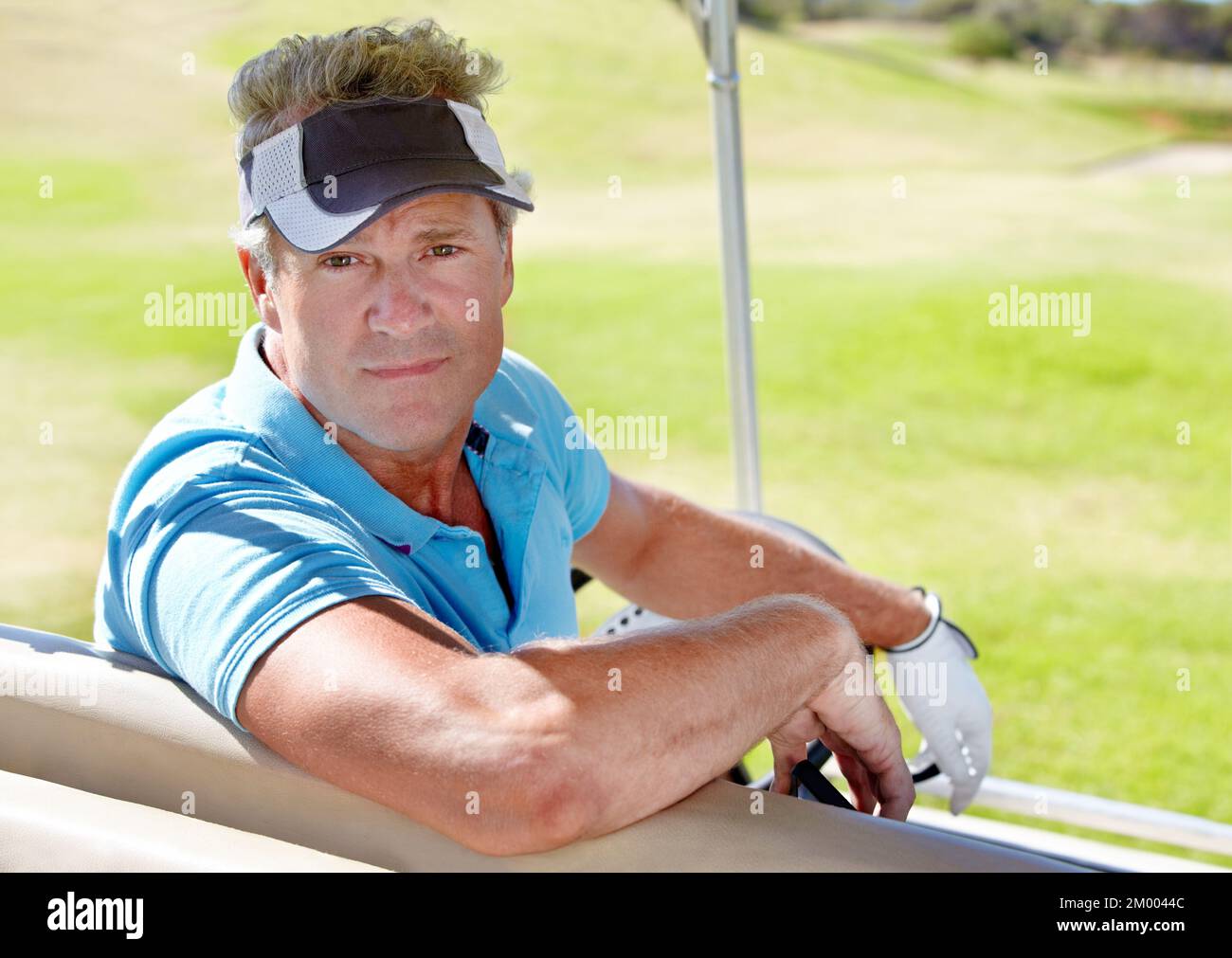 Ich brauche eine Mitfahrgelegenheit zum nächsten Loch. Porträt eines reifen Golfers, der in einem Golfwagen sitzt. Stockfoto