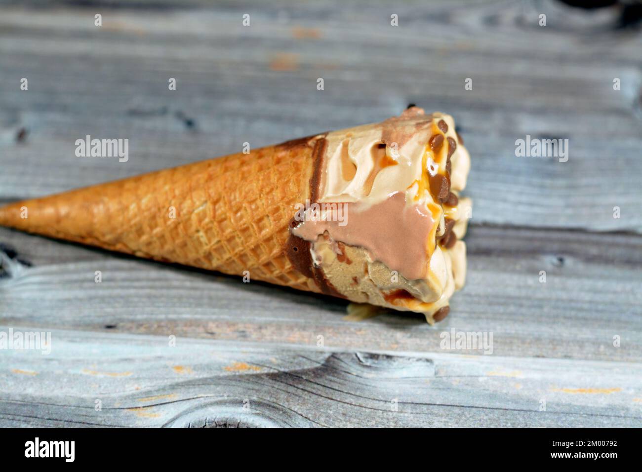 Eiscreme aus Kakao-, Schokoladen- und Vanilleeis mit Schokoladenstückchen in knusprigen Waffeln, selektiver Fokus auf schmelzendes kaltes Eis Stockfoto