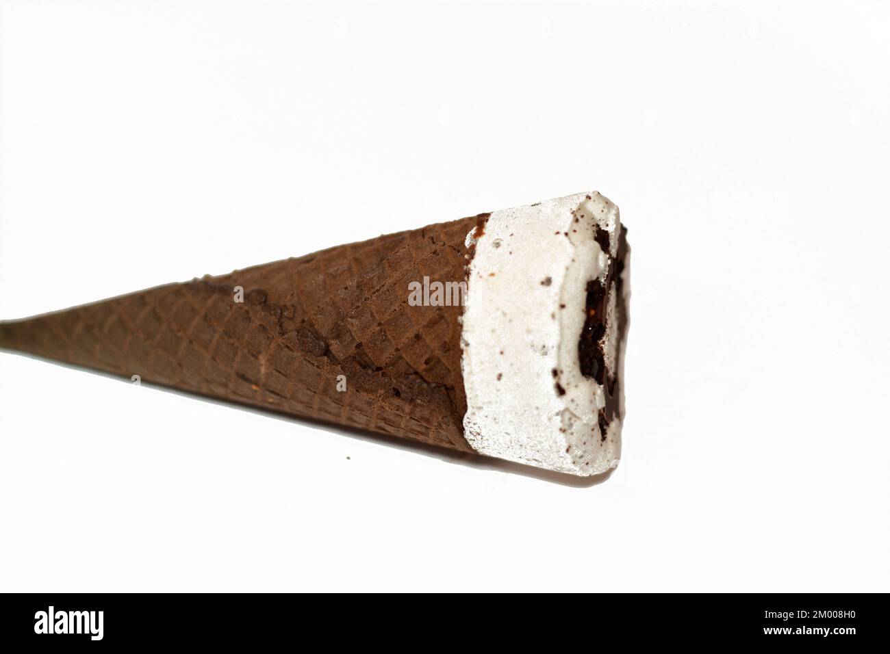 Eiscreme-Vanillekonus mit Schokoladenstückchen in knusprigen Waffelkonus, selektiver Fokus auf Schmelzen von kaltem Eis in einer waffel-bisc Stockfoto