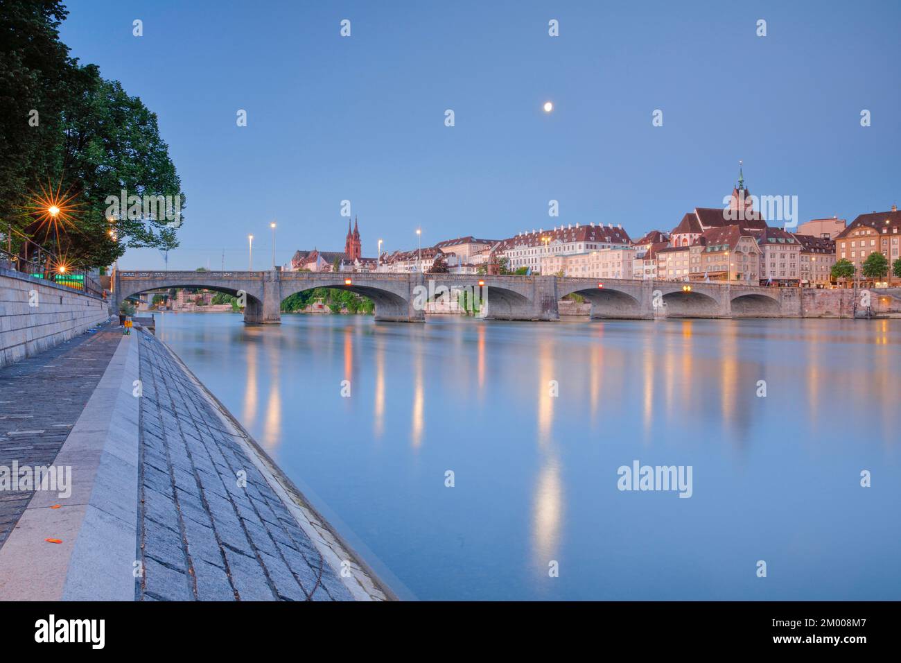 Blick auf die Altstadt von Basel beleuchtet bei Nacht mit dem Basler Dom, der St. Martins Kirche, der Mittleren Brücke und dem Rhein Stockfoto