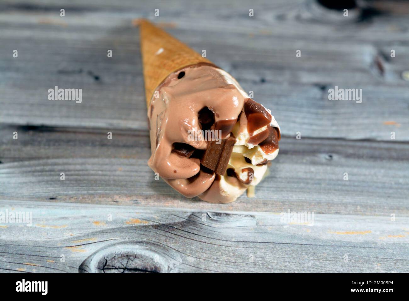 Eiscreme aus Kakao, Schokolade und Vanille mit einem Schokoriegel in knusprigen Waffeln, selektiver Fokus des Schmelzens von kaltem Eis in einem w Stockfoto