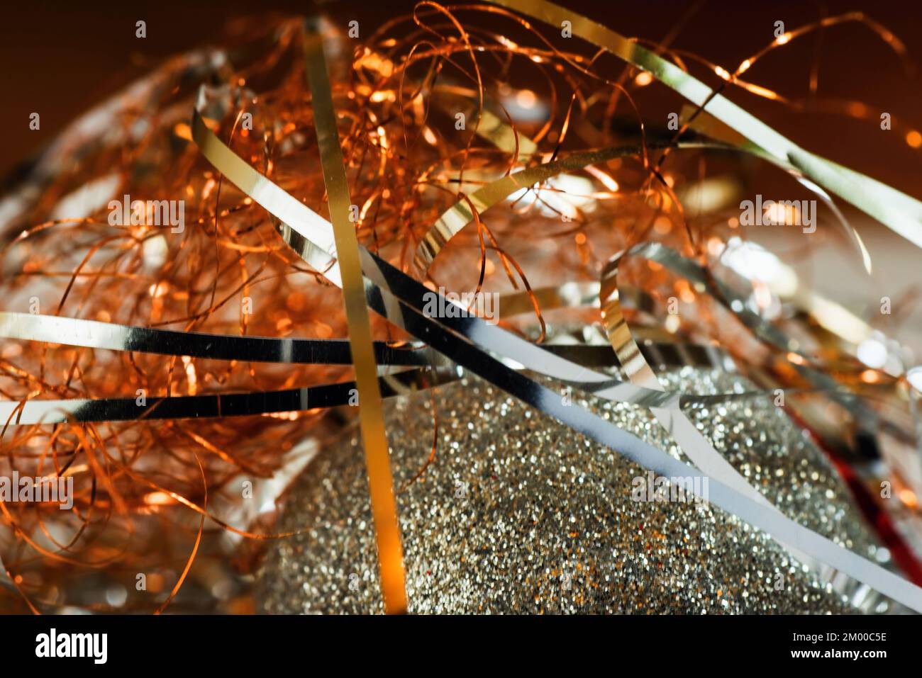 Glitzernde metallische Weihnachtsfäden auf der Oberfläche des weihnachtsballs, Nahaufnahme. Stockfoto