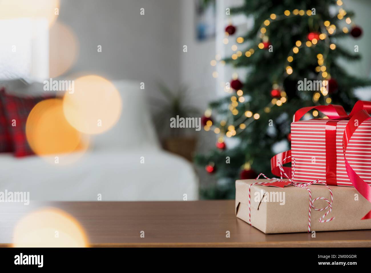 Hintergrund für Weihnachten und Neujahr mit Kopierbereich für Design. Leere Tischplatte, verschwommene dekorierte Tannenbaumzusammensetzung, Bokeh-Lichter Stockfoto
