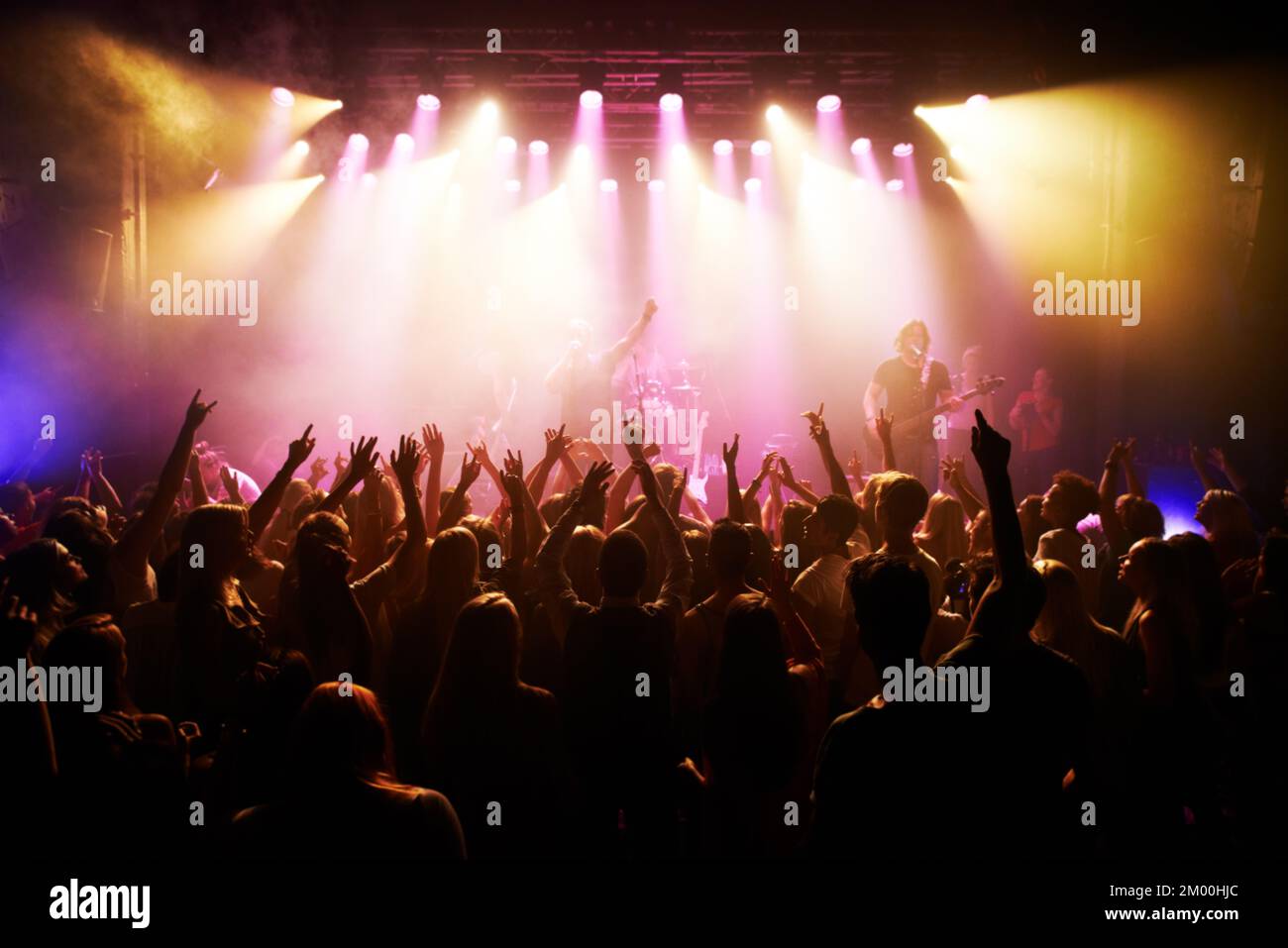 Festival, Musik und Konzert mit der Energie der Zuschauer, die die Live-Rockband auf der Bühne anfeuern. Event, Fans und fröhliche Menschen jubeln für energiegeladene Leistung bei Stockfoto