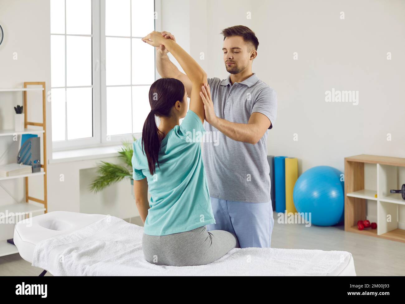 Chiropraktiker, Physiotherapeut oder Osteopath, der jungen Frau in der Rehabilitation hilft