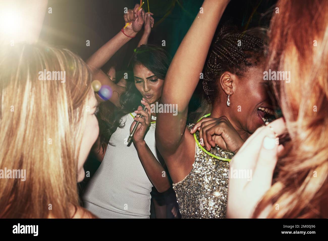 Partyfrauen und Tanz im Nachtclub Rave mit Leuchtstäbchen für fröhlichen Spaß, Jugend und Feiern. Gemischtrassige Menschen, Veranstaltungen und glückliche Menschen, die zusammen tanzen Stockfoto