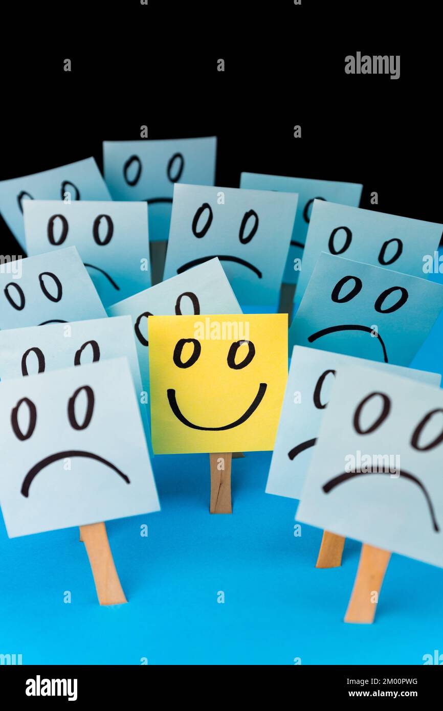 Haftnotizen mit handgezeichneten Smiley-Gesichtern und traurigen Gesichtern. Positive Denkweise. Positiver Verstand überwindet negatives. Stockfoto