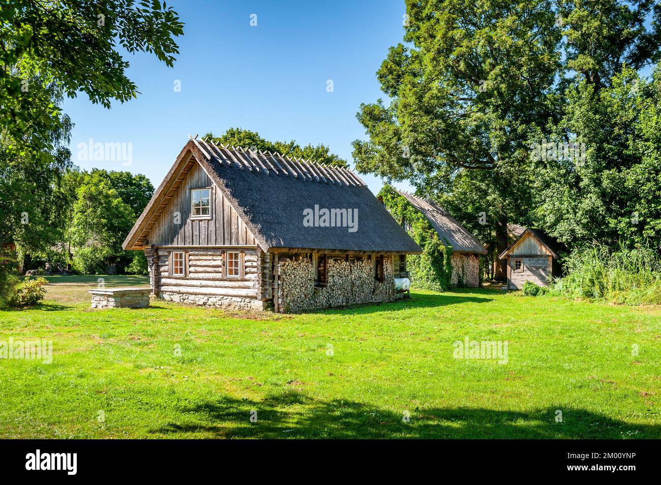 Ein Beispiel für die Holzarchitektur der Insel Ruhnu. Holzhaus mit gestapeltem Brennholz. Brennholz, das im Winter zum Heizen geerntet wurde. Stockfoto