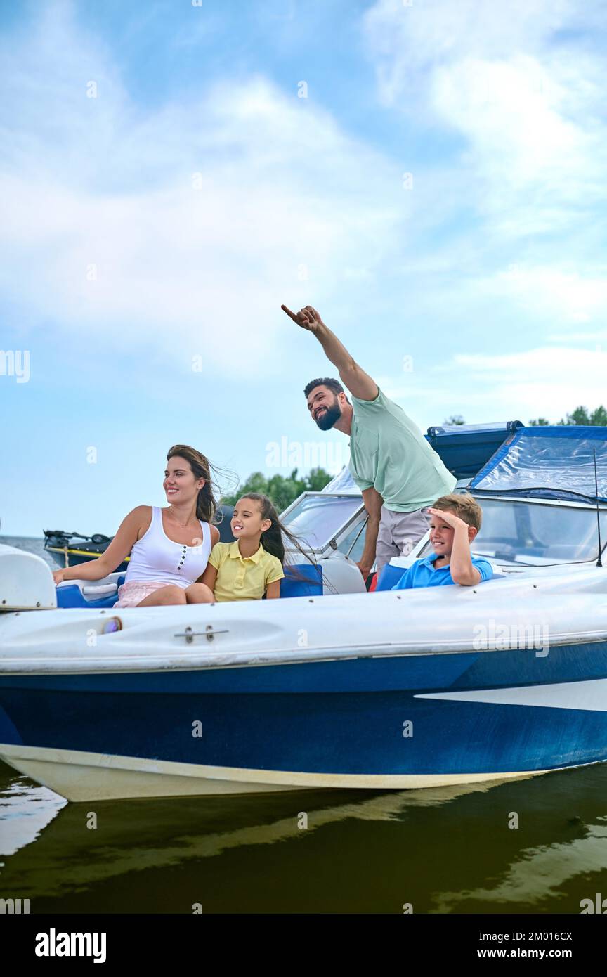 Eine Bootsfahrt. Eine süße Familie, die eine Bootsfahrt macht und fröhlich aussieht. Stockfoto