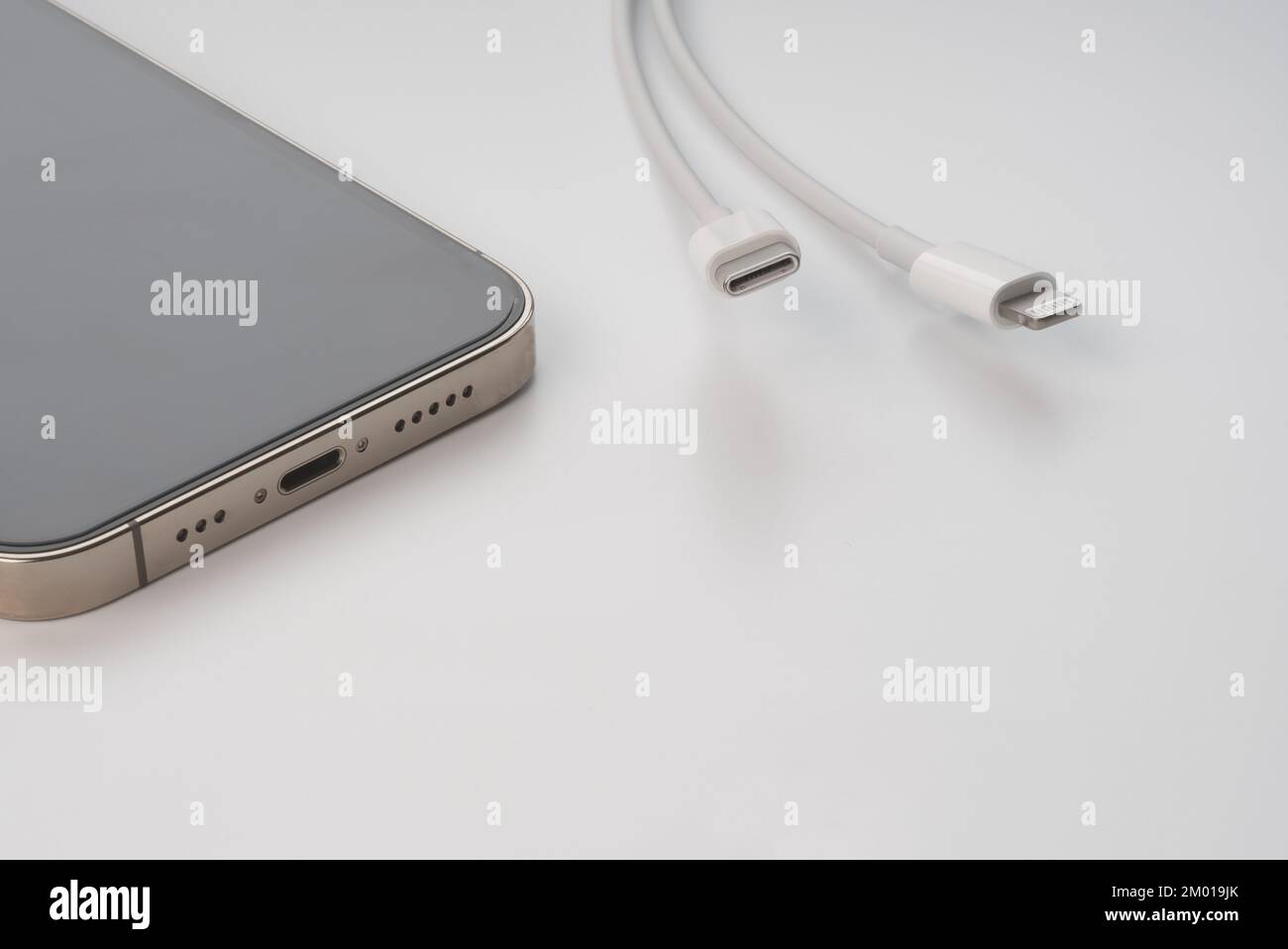 Apple iPhone 13 Pro und kabelgebundenes USB-C- oder Typ-C-Ladegerät. EU (Europäische Union) zwingt alle Geräte zur Verwendung von USB-C oder Typ-C. Stockfoto