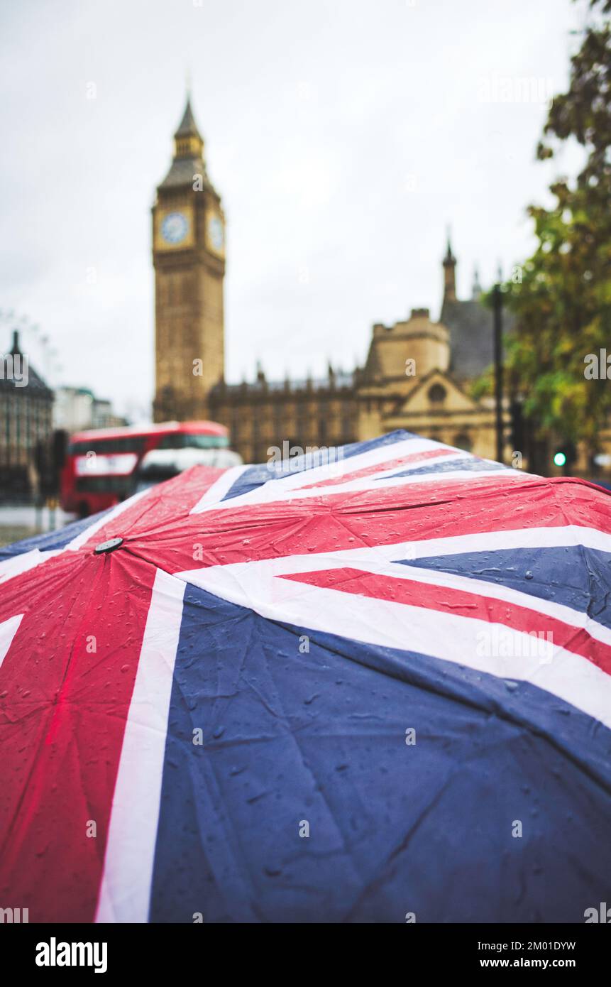 Regen auf einem Union-Jack-Regenschirm mit Big Ben im Hintergrund Stockfoto