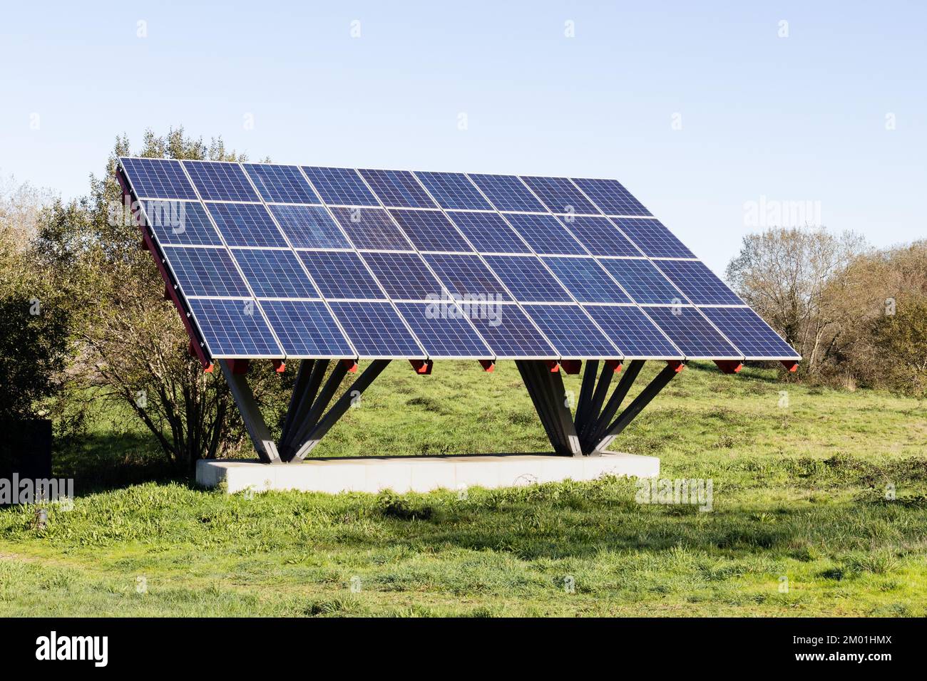 Solarpaneele, die auf einer Metallkonstruktion in einem Feld installiert sind, das Haushalte oder Gebäude mit Strom versorgt Stockfoto