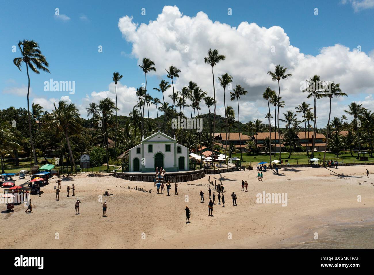 Praia dos Carneiros, Pernambuco, Brasilien - 09. November 2022 - Kirche mit Kokospalmen im Hintergrund und Touristen davor am Strand Stockfoto