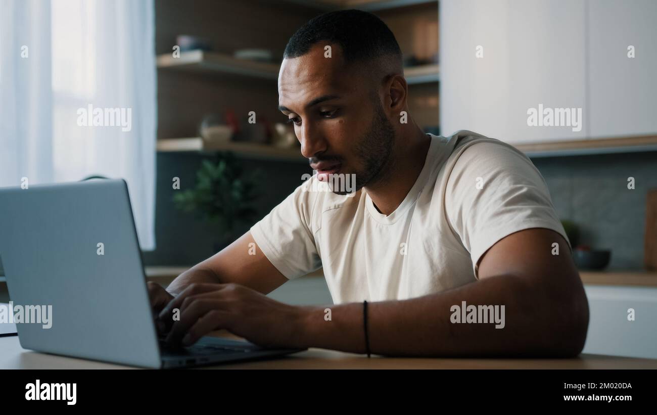 Afroamerikanischer Mann in der Küche zu Hause spielen Online-Spiel-Wette verlieren Wetten schlechte Ergebnisse fühlen sich frustriert verärgert Probleme mit dem Geschäft scheitern mit Stockfoto