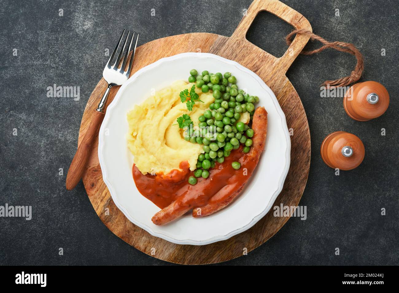 Knaller und Püree. Gegrillte Würstchen mit Kartoffelpüree und grüner ...