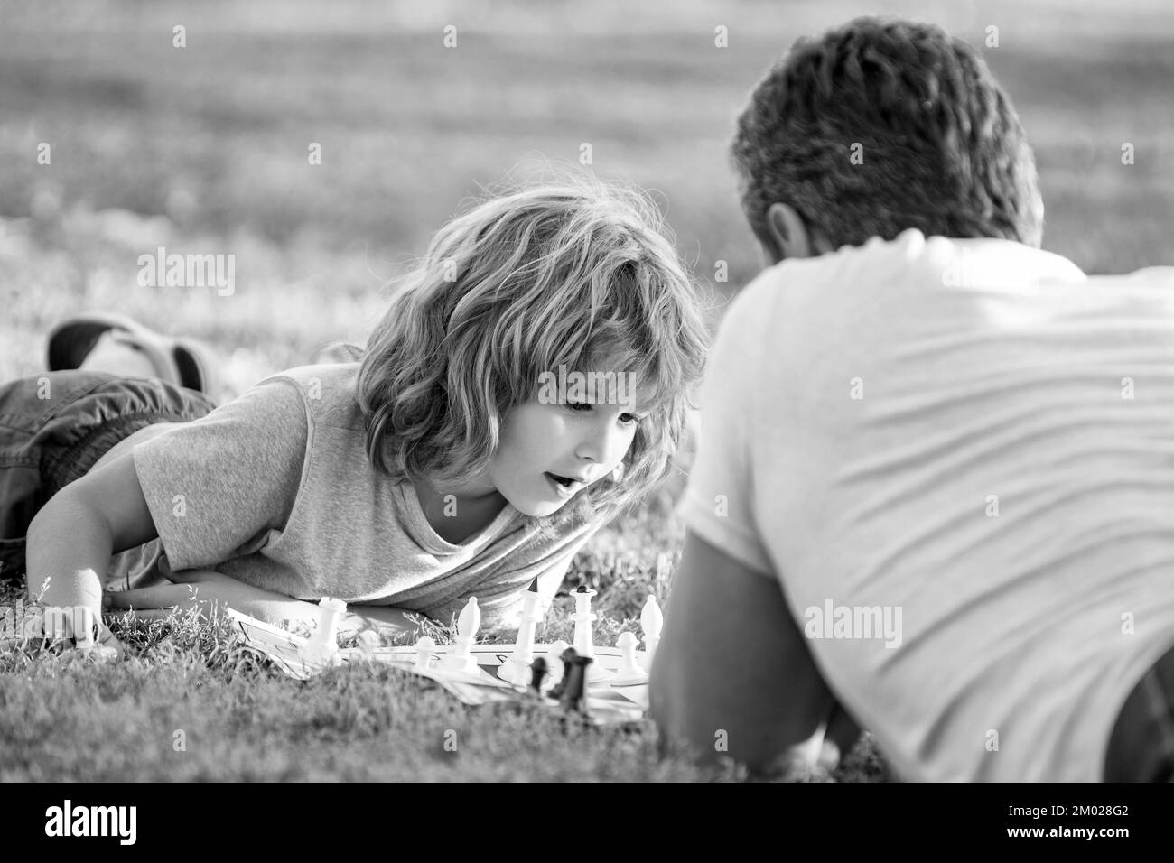 Elternschaft und Kindheit. Schachmatt. Zeit miteinander verbringen. Strategisch und taktisch. Unterricht. Dad und Kind spielen Logikspiel. Vater und neugieriger Sohn spielen Stockfoto