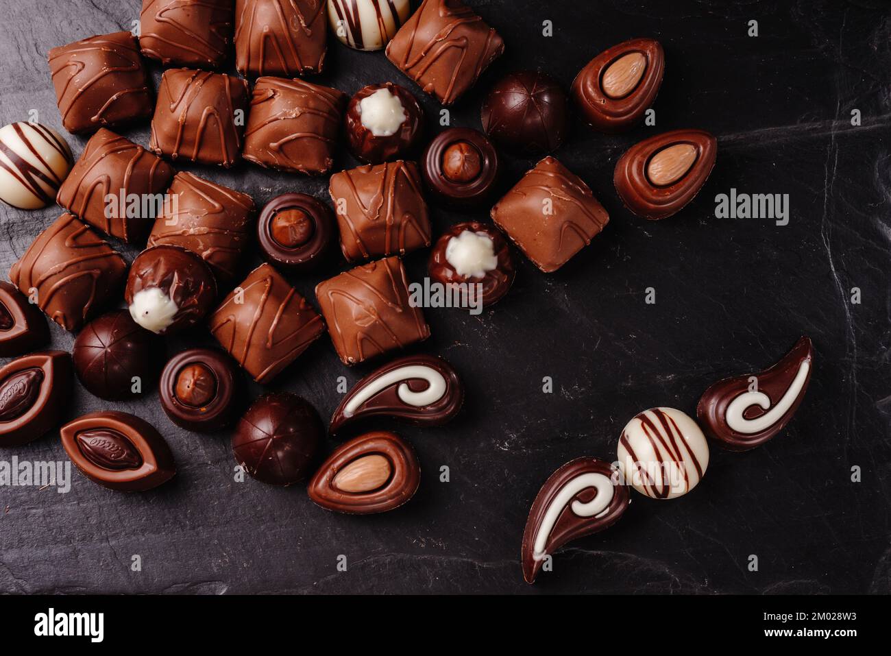 Schokoladenbonbons mit verschiedenen Füllungen, süßer Essenshintergrund. Kombiniere verschiedene Süßigkeiten. Schokolade mit verschiedenen Füllungen, süßes Essen Stockfoto