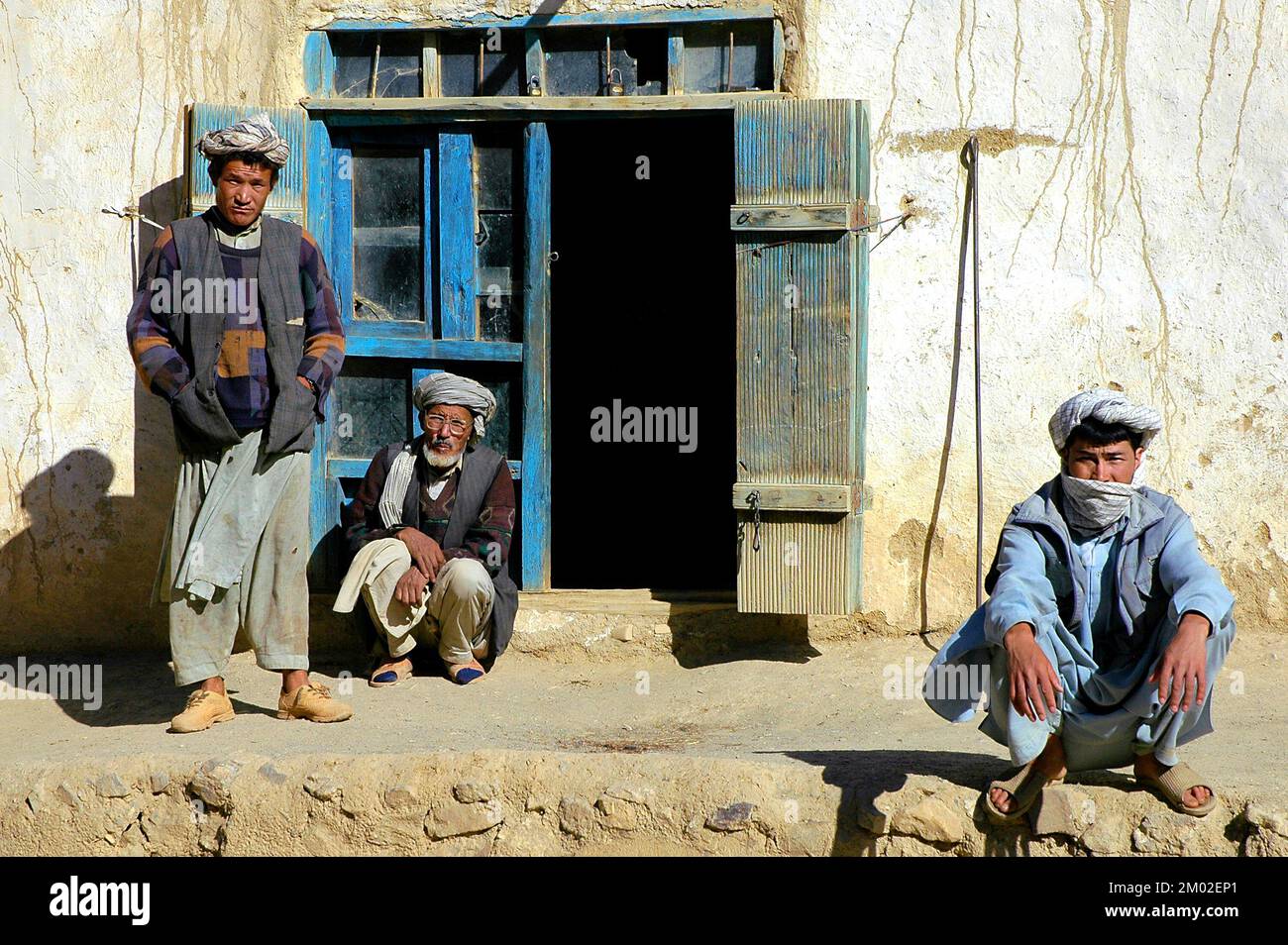 Syadara (Siyah Darah), Provinz Bamyan (Bamiyan)/Afghanistan: Drei afghanische Männer mit Turbanen vor einem Haus in Zentralafghanistan. Stockfoto