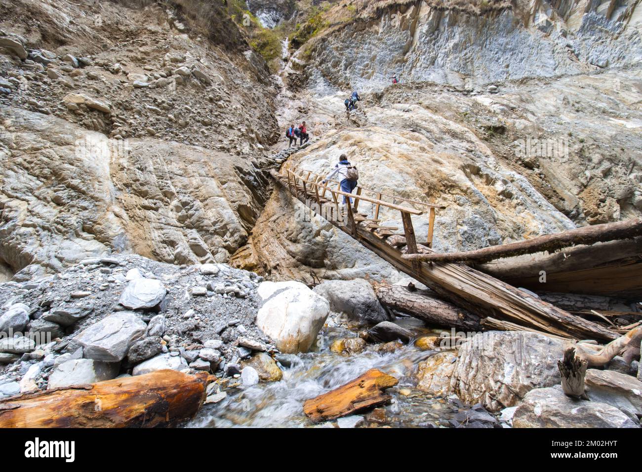 Gefährliche Straßen im Himalaya. Ein Mädchen überquert gefährliche Brücke Abenteuer in den Bergen Stockfoto