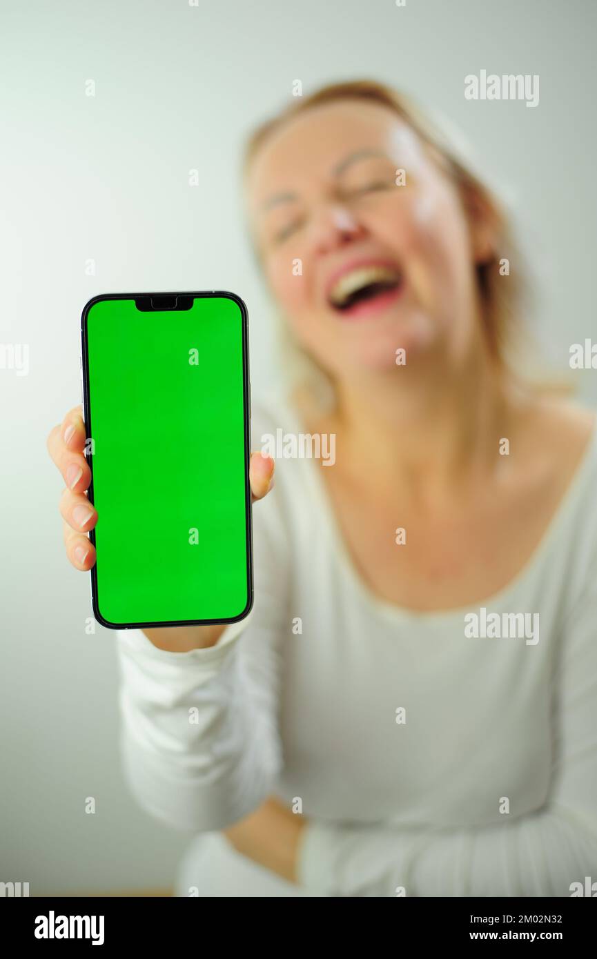Gewinnen, um zu finden, was Freude Freude Freude Freude Freude Freude andere Emotionen Chroma Key Phone Grünes Bildschirmfeld für Werbung schöne Erwachsene glückliche Frau Stockfoto