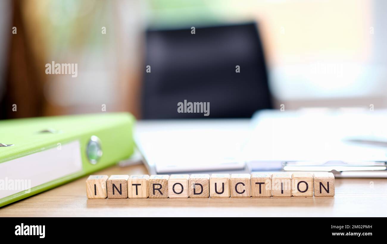 Worteinführung auf Schreibtisch und leerem Stuhl im Hintergrund. Stockfoto
