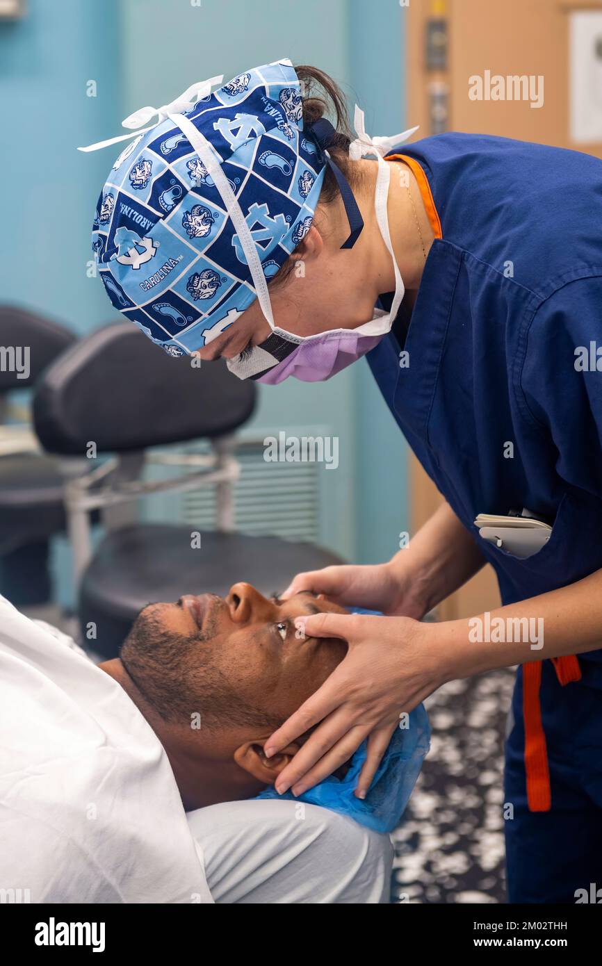 Ein Augenarzt untersucht einen Patienten nach einem chirurgischen Eingriff. Stockfoto