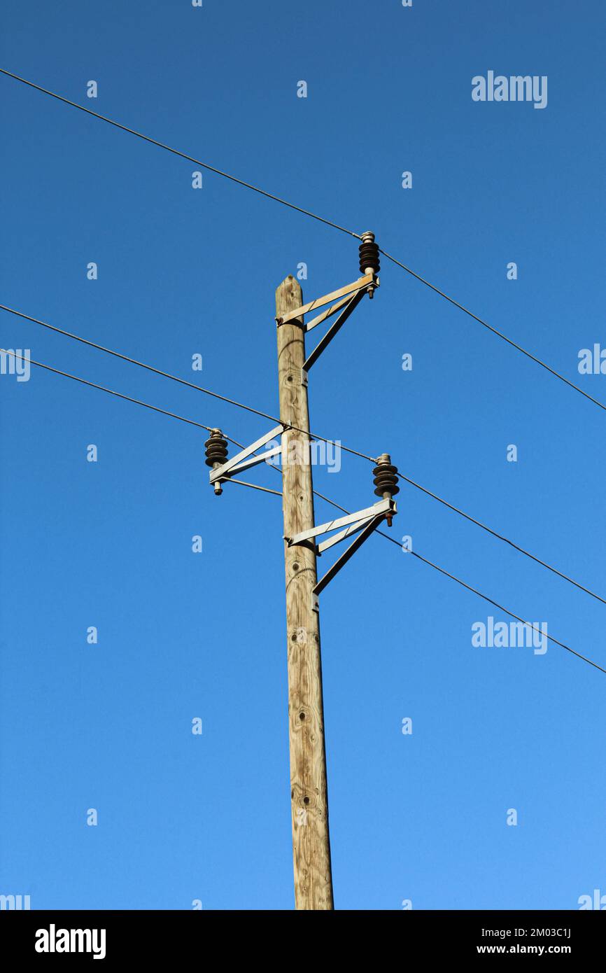 Holzstange mit Stromleitungen. Stromübertragungskabel Stockfoto