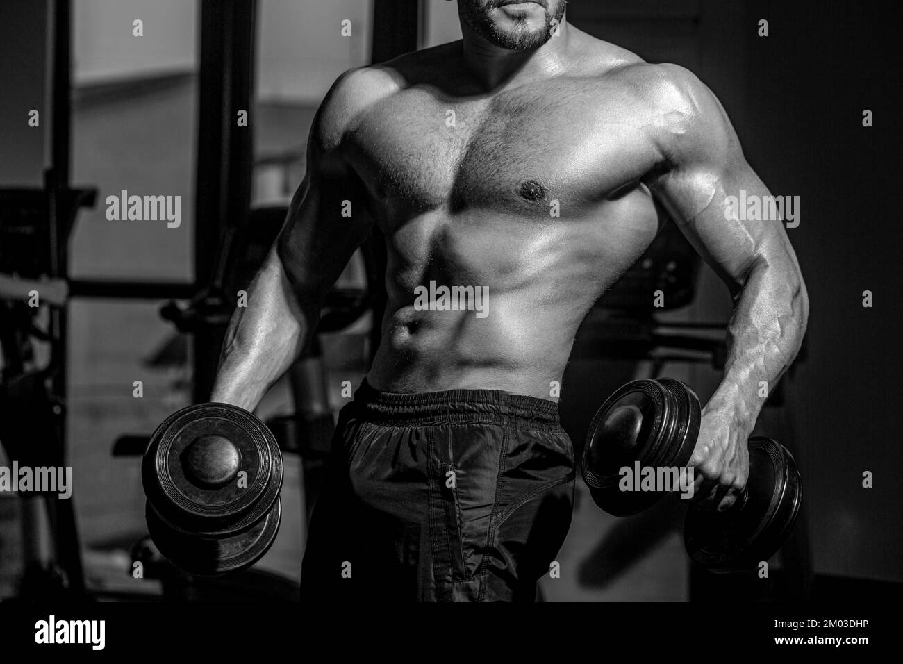 Ein Mann, der mit der Kurzhantel trainiert. Sportler im Fitnessstudio ...