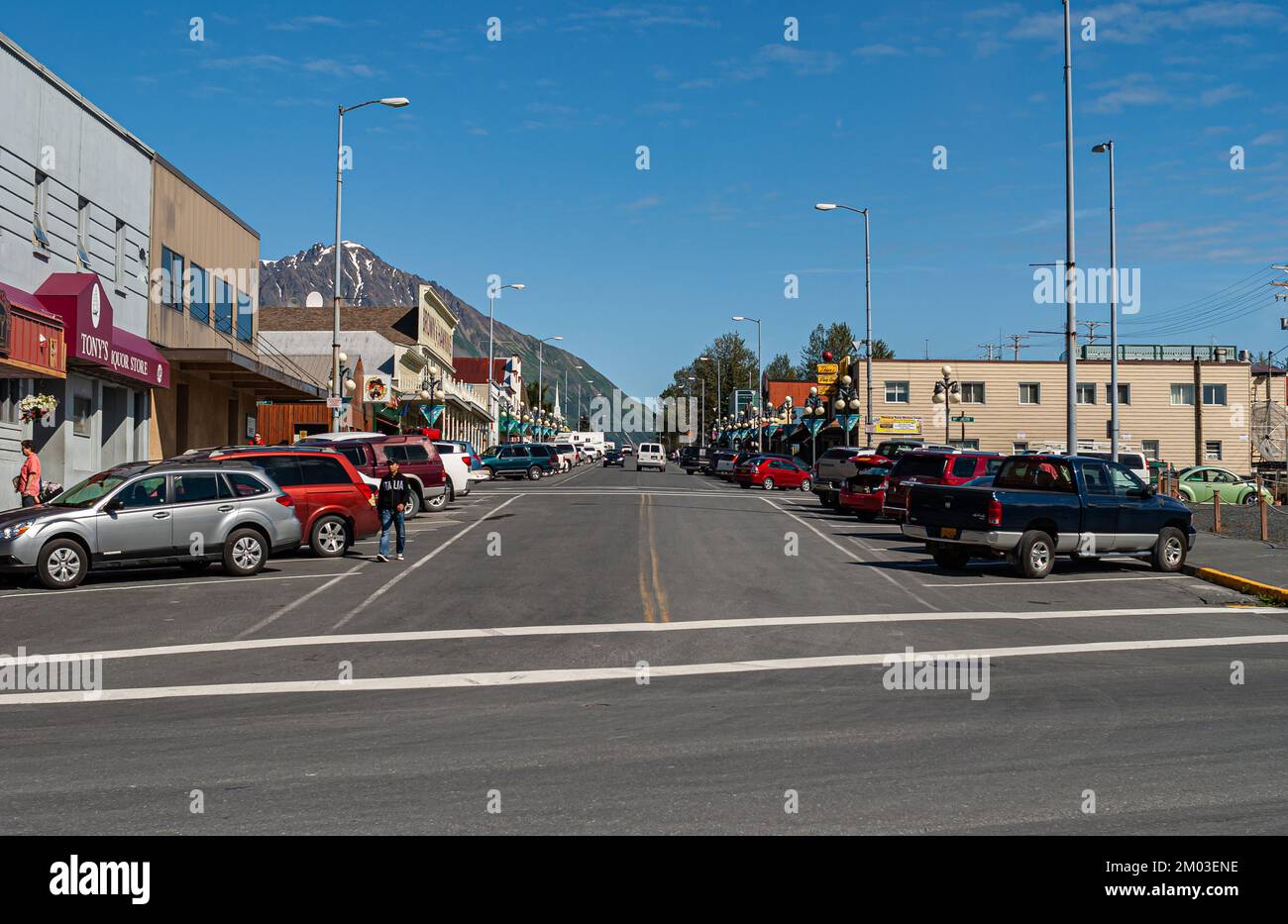 Seward, Alaska, USA - 22. Juli 2011: Looking nord from southend 4. Ave zeigt alle Fassaden von Einzelhandelsgeschäften in verschiedenen Farben und geparkten Autos unter Blau Stockfoto