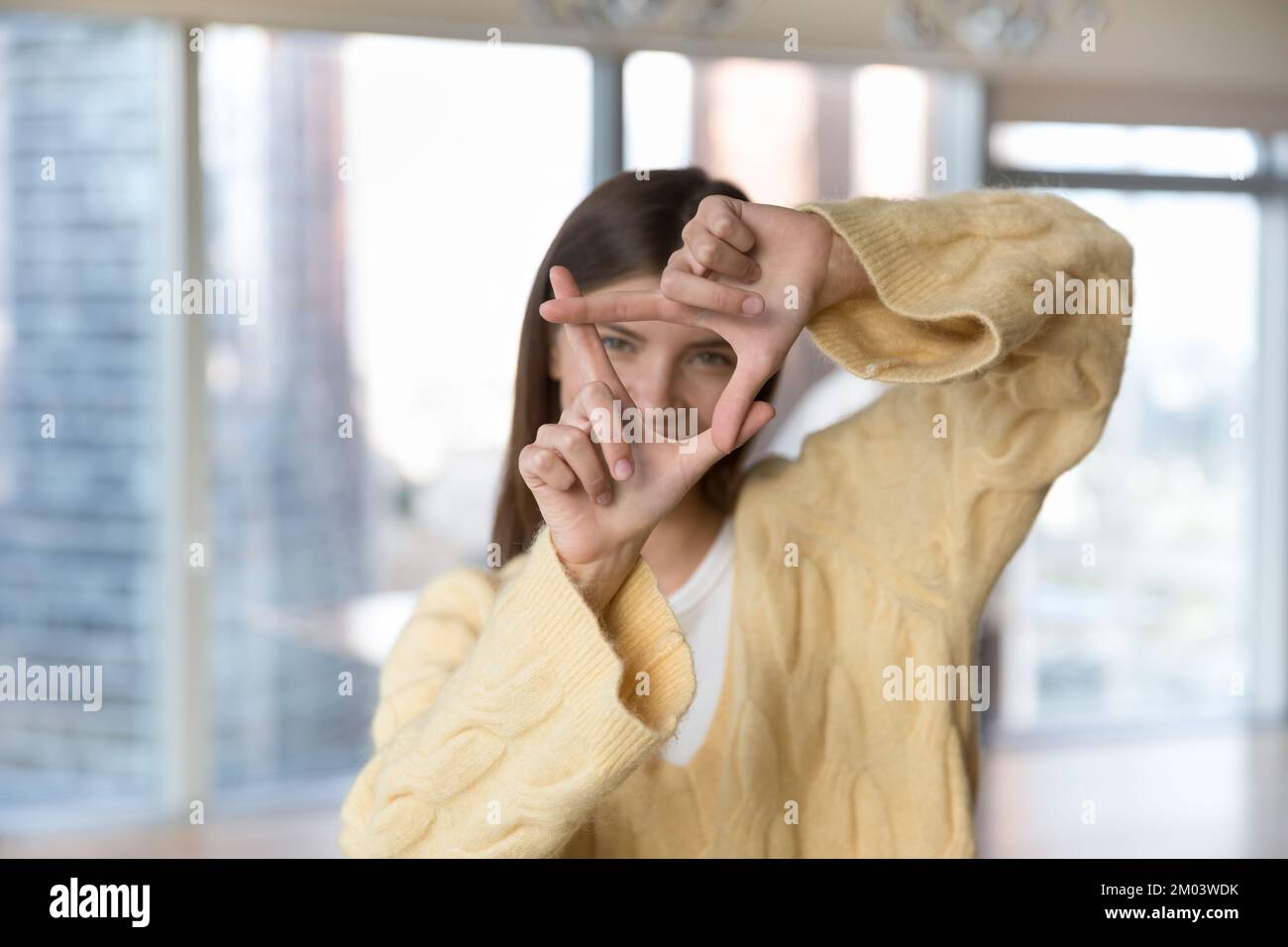 Hübsches, junges Mädchen in warmem Pullover, das ein Fingerfoto macht Stockfoto