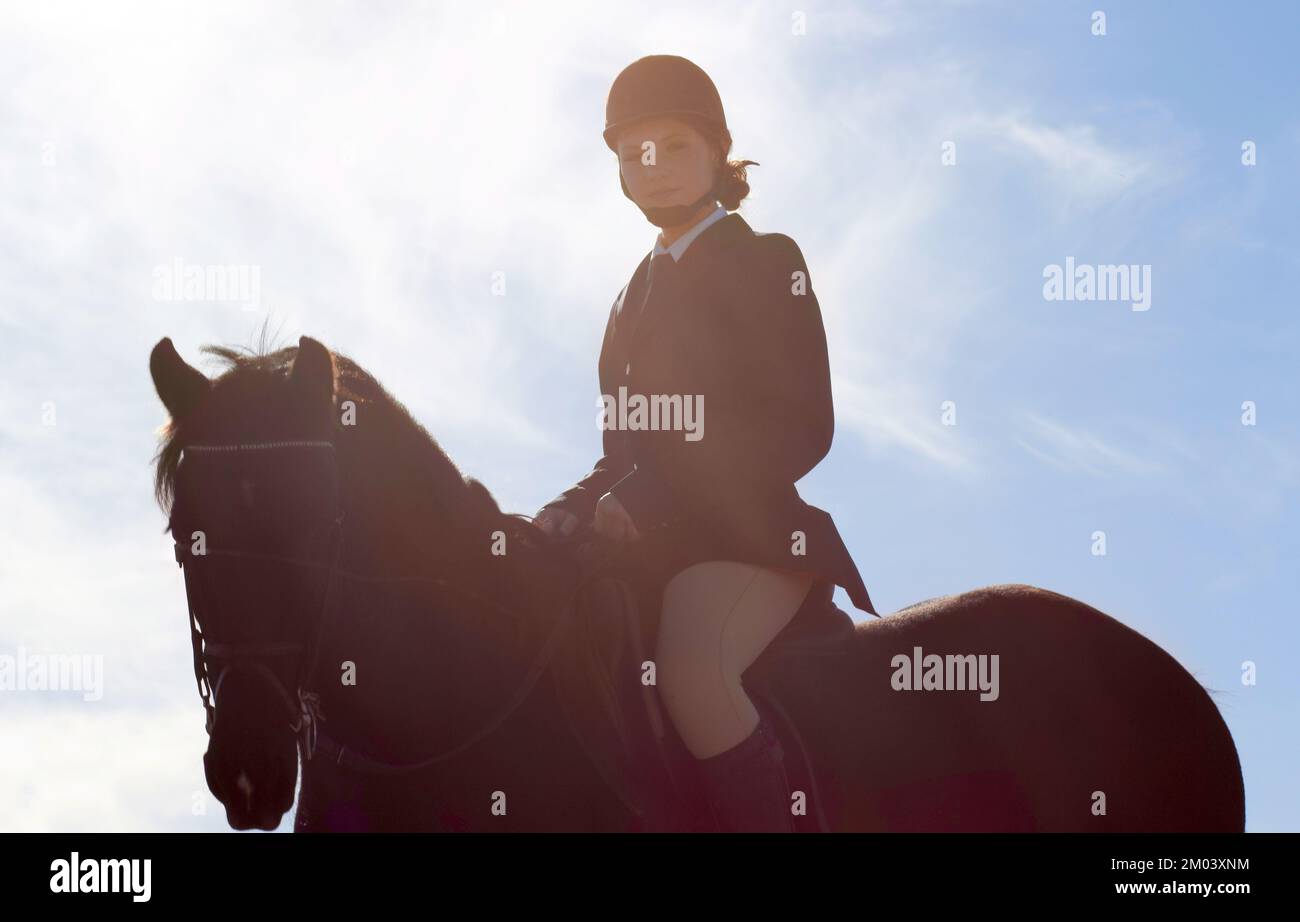 Er reitet wie der Wind. Eine wunderschöne junge Frau, die auf ihrem Pferd reitet. Stockfoto