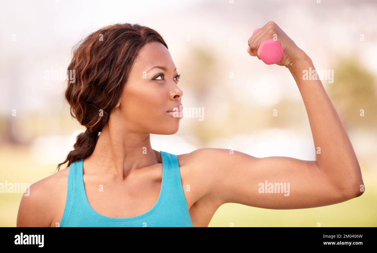 Krafttraining zur Stärkung. Eine junge Frau, die draußen Krafttraining macht. Stockfoto
