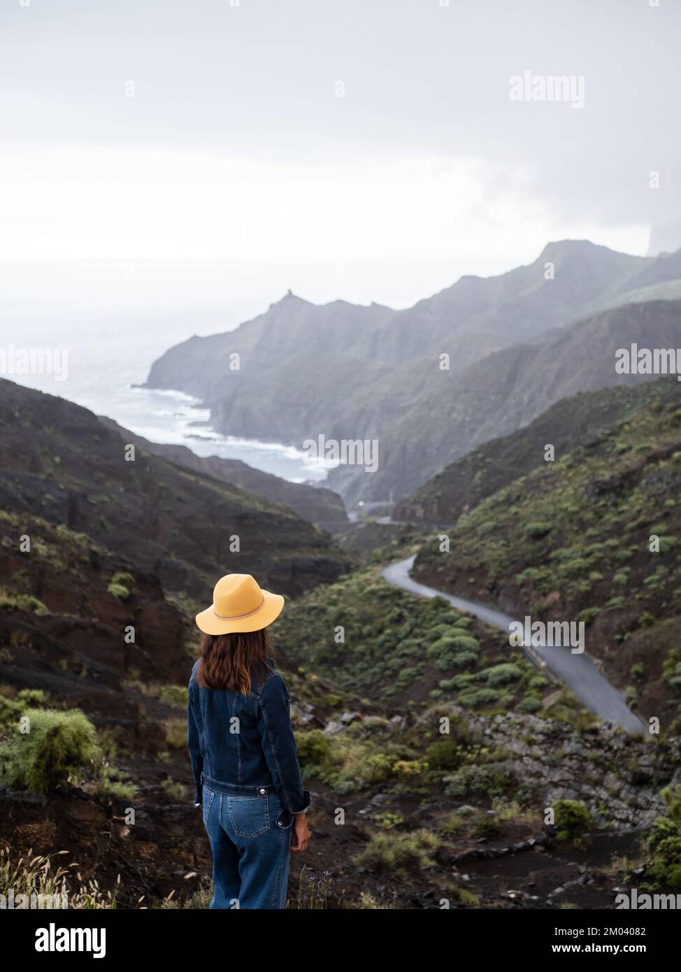 Frau von hinten, die die Landschaft der grünen Berge und das Meer am Mirador de la Orilla in La Gomera, Kanarische Inseln, bewundert Stockfoto