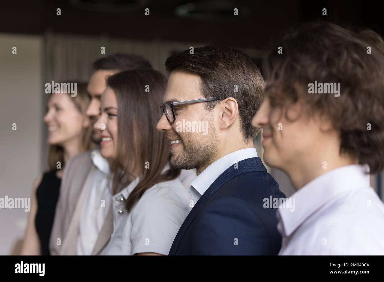 Geschäftsleute stehen in der Reihe, schauen nach vorne, Seitenprofil blickt auf Stockfoto