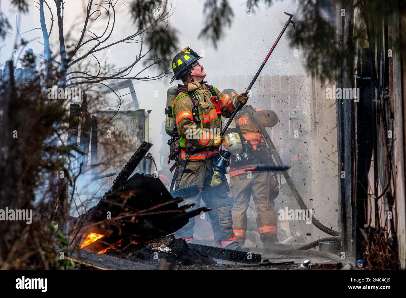 Reno, Usa. 03.. Dezember 2022. Ein Feuerwehrmann zieht brennendes Material aus einem Gebäudebrand heraus. Zwei unbesetzte Häuser, die während eines Schneefalls im Winter verbrannt wurden. Die Ursache ist unbekannt, und die Untersuchungen haben begonnen, die Ursache zu ermitteln. Kredit: SOPA Images Limited/Alamy Live News Stockfoto