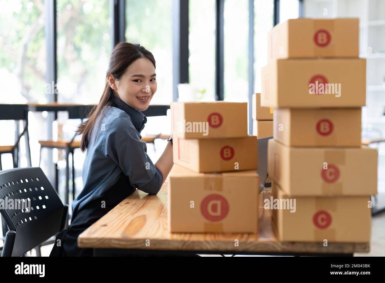 KMU-Unternehmer kleine Unternehmer Online-Verkaufsideen, Happy Young asiatischer Unternehmer arbeitet an Computer und einer Box zu Hause, Lieferung Stockfoto