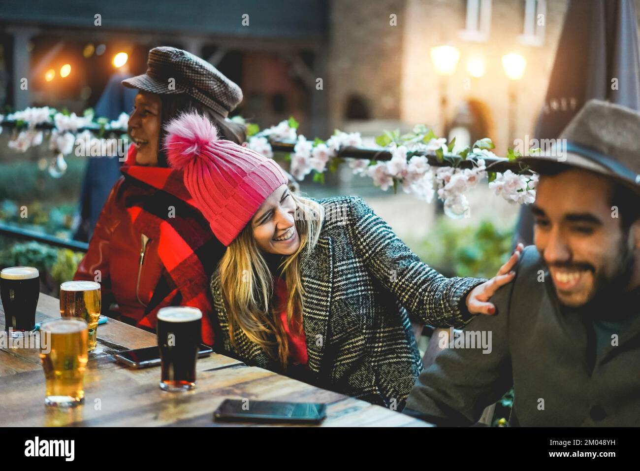 Junge Leute, die Spaß beim Biertrinken im Pub-Restaurant haben - Weiche Konzentration auf Mädchen im Zentrum Stockfoto