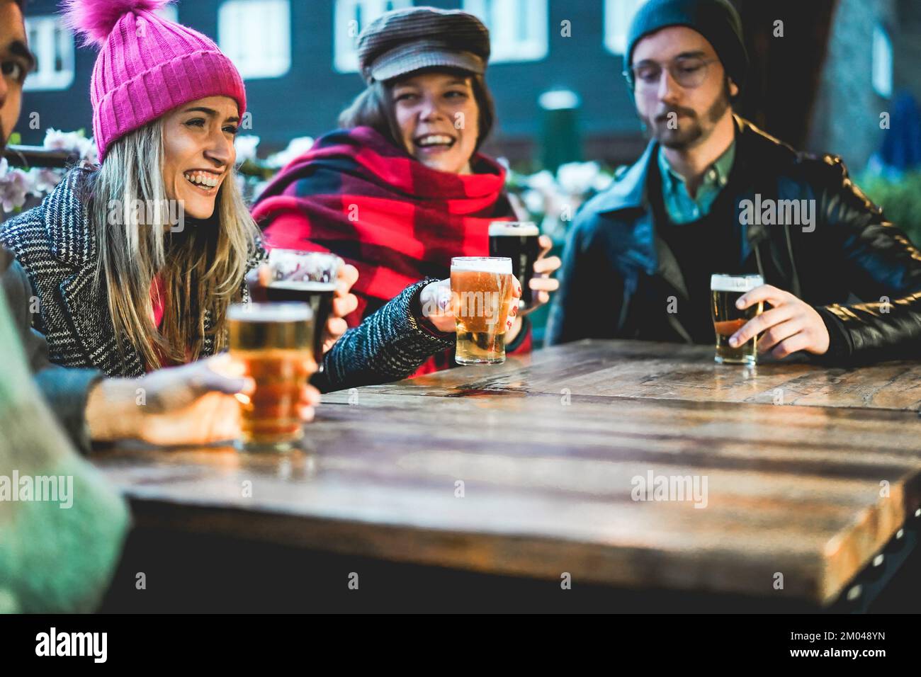 Junge Leute, die Spaß beim Biertrinken im Pub-Restaurant haben - Weiches Augenmerk auf das linke Mädchengesicht Stockfoto