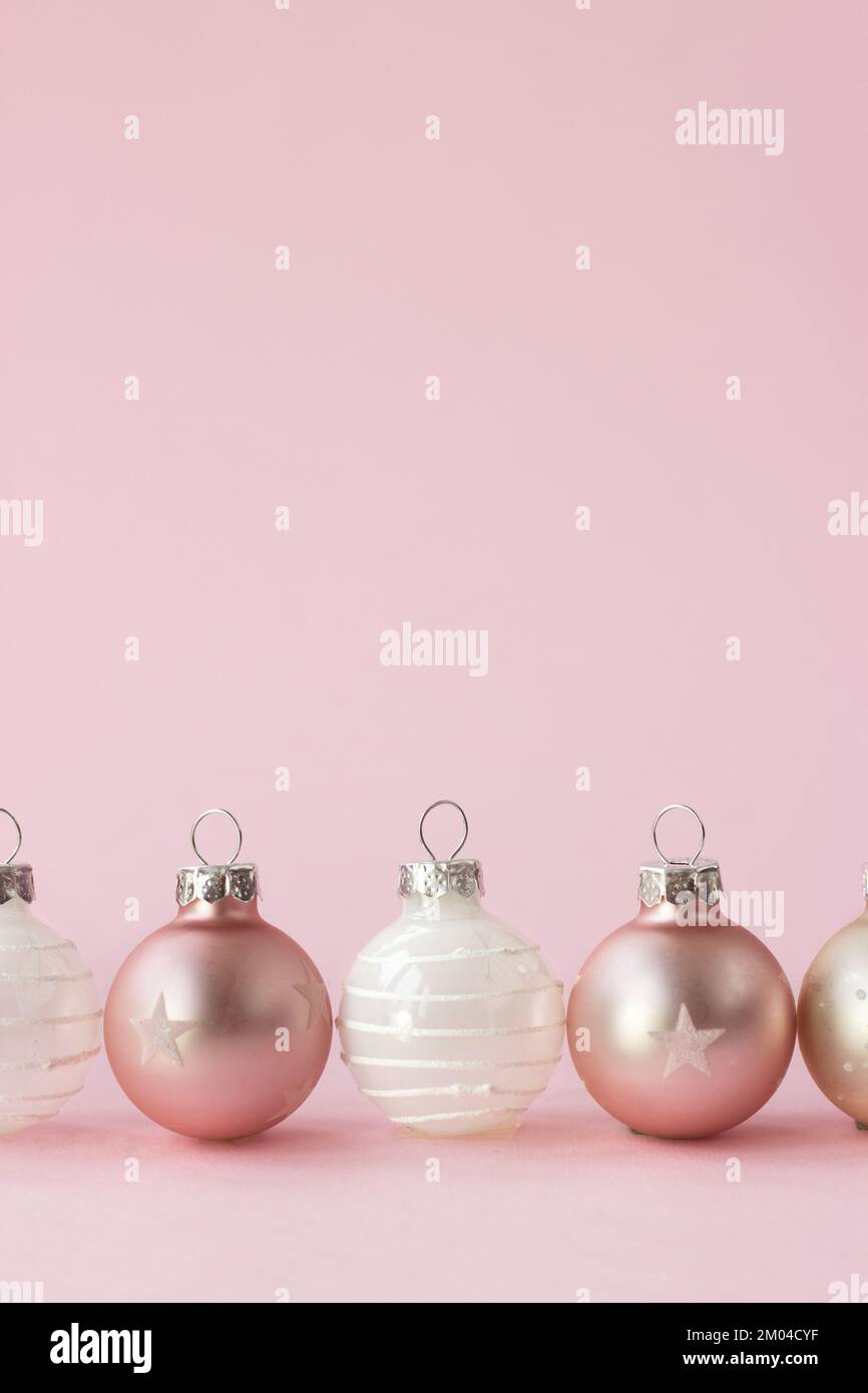 Weihnachtskugeln in Champagnerfarbe auf pinkfarbenem Hintergrund; Minimales Weihnachtskonzept mit Kopierbereich Stockfoto