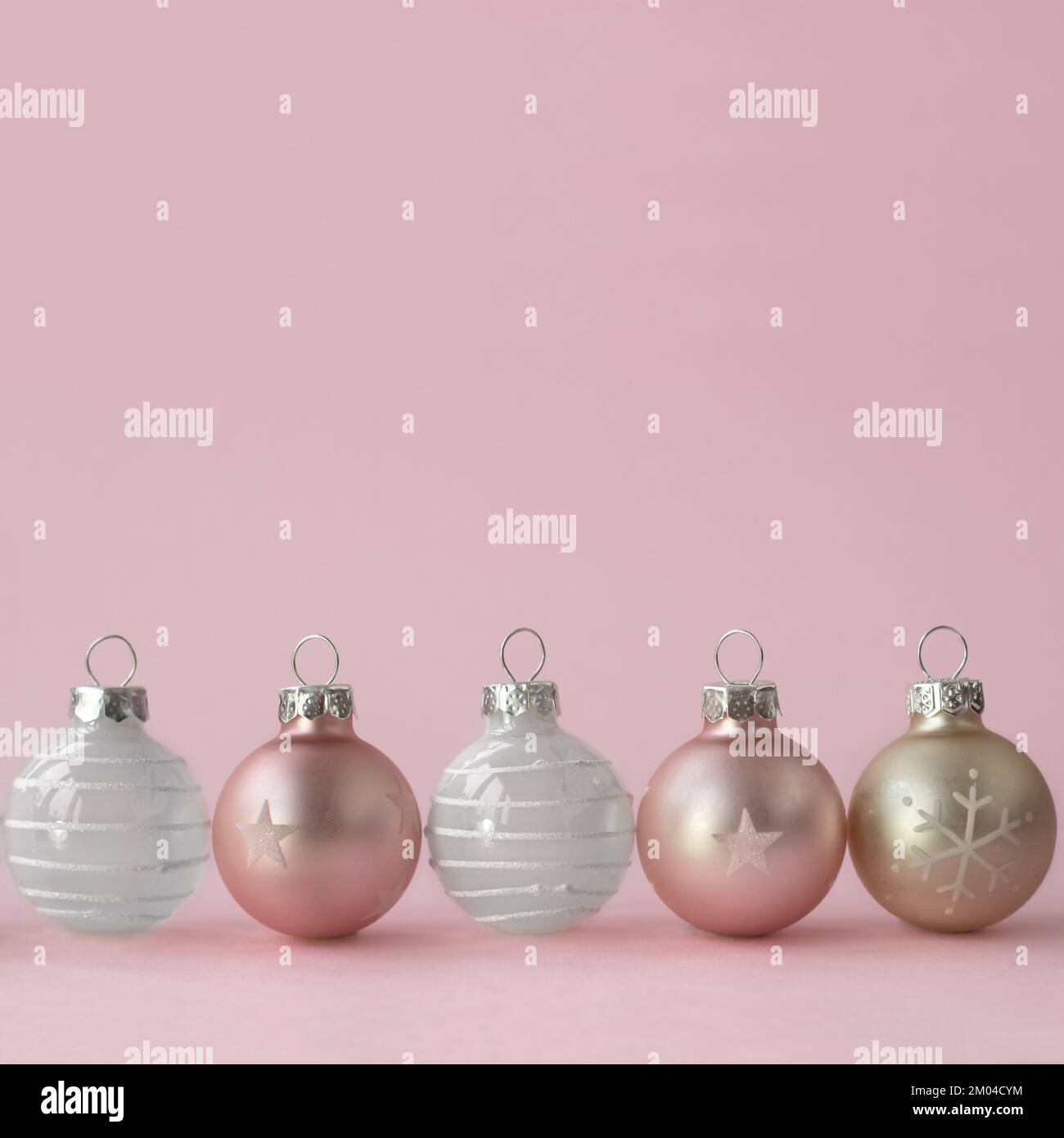 Weihnachtskugeln in Champagnerfarbe auf pinkfarbenem Hintergrund; Minimales Weihnachtskonzept mit Kopierbereich Stockfoto
