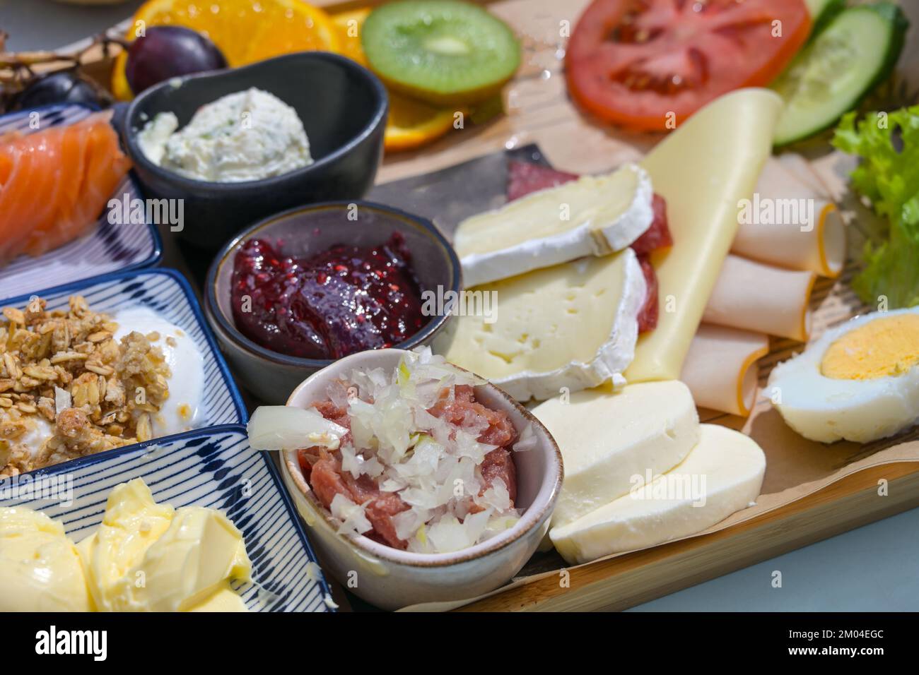 Mittags- oder Frühstücksbüffet mit verschiedenen Zutaten wie Aufschnitt, Käse, Obstmarmelade und mehr, ausgewählter Schwerpunkt, schmale Feldtiefe Stockfoto
