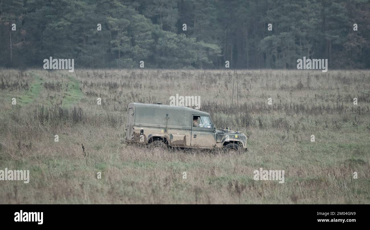 Die britische Armee Land Rover Defender Wolf Leichtes Nutzfahrzeug, das sich auf einer Schlammstrecke auf einer Militärübung in Wiltshire UK bewegt Stockfoto