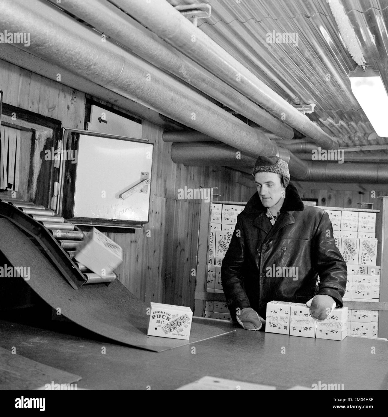 Eiscreme in den 1960er. Das Innere einer Eiscremefabrik, in der Eiscreme hergestellt wird und in fertiger Form, verpackt und vertriebsbereit zu sehen ist. Ein Mann wird im eiskalten Lagerraum gesehen, gekleidet in warmer Kleidung. Schweden 1965 Ref. CS88-9 Stockfoto