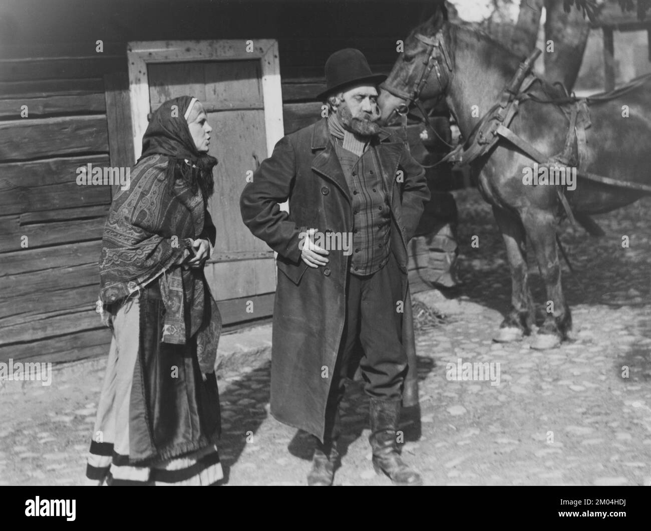 Theater in den 1930er Jahren. Ein älteres Paar in historischen Kleidern führt draußen etwas für ein Publikum auf. Ein altes Haus und ein Pferd sind im Hintergrund zu sehen. 20. Mai 1939. Schweden Stockfoto