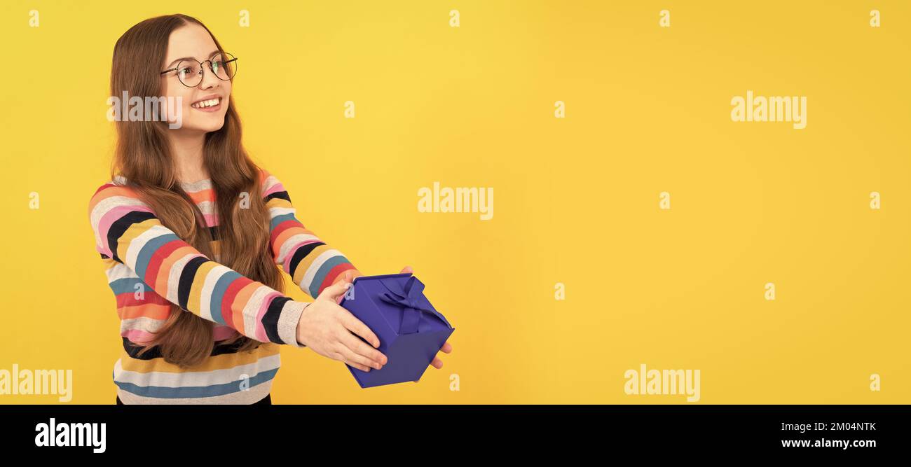 Glückliches Kind in Brillen teilen Geschenk-Box für den Tag. Kind mit Geburtstagsgeschenk, horizontales Poster. Banner-Kopfzeile mit Kopierbereich. Stockfoto