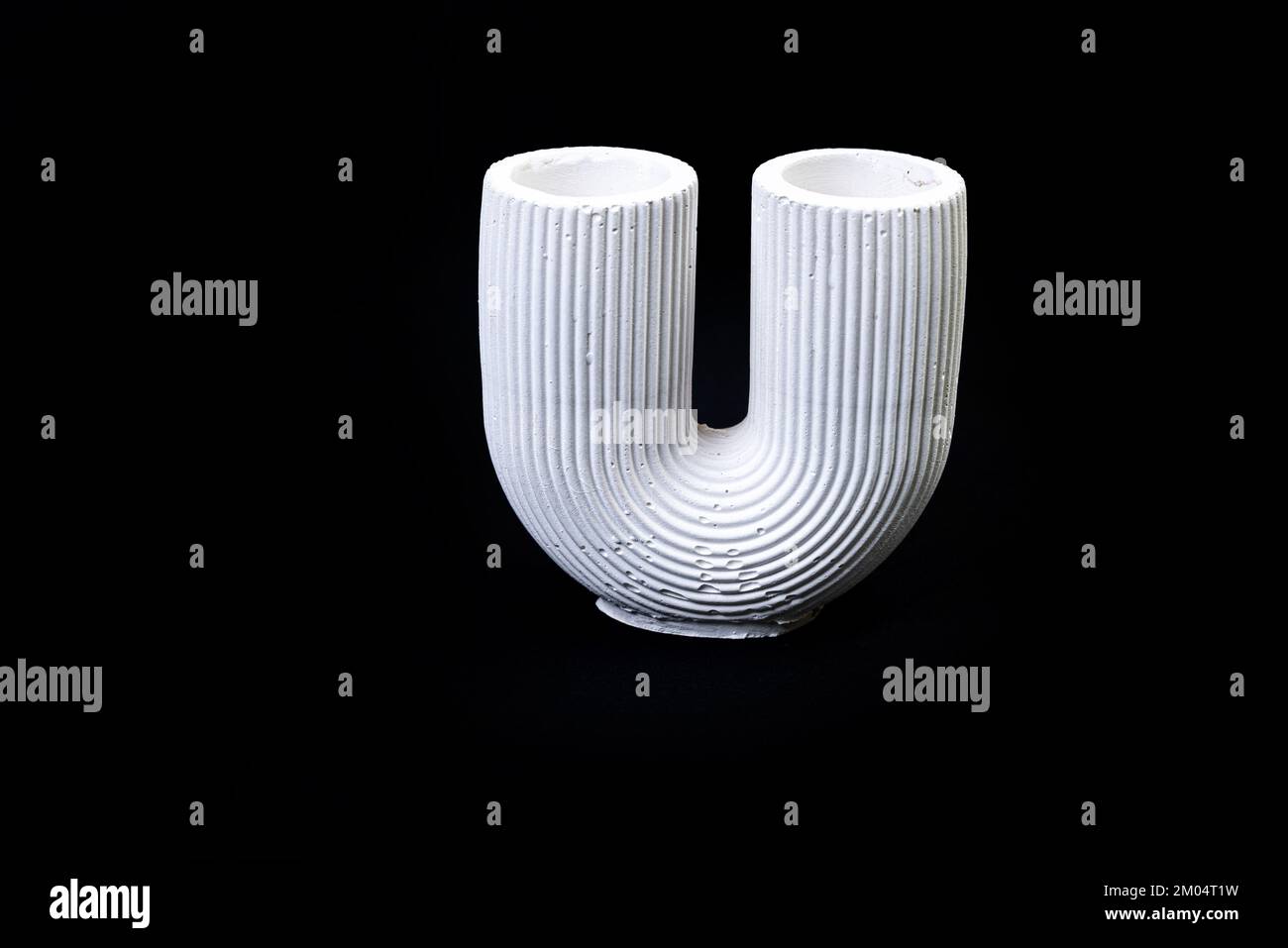 Gipssäule mit Schüssel, Vase mit Stuckverzierungen in Form von Blumenverzierungen, Gipsvase in Form einer antiken Säule. Moderne Kunst. Modus Stockfoto