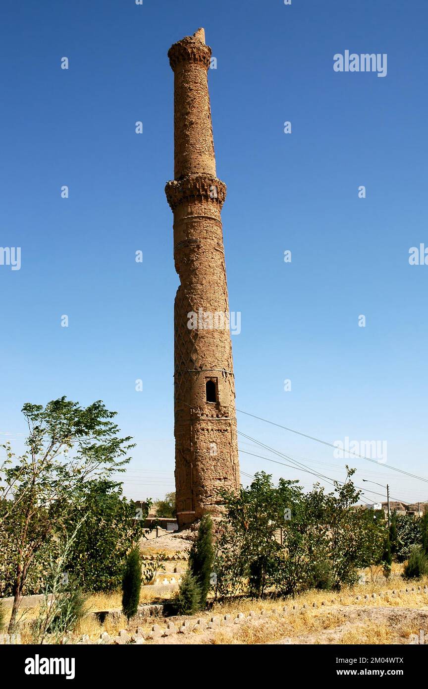 Herat in Afghanistan. Eines der Musalla-Minarette von Herat, Teil des Musalla-Komplexes. Dieses Minarett neigt sich in einem unsicheren Winkel, der von Kabeln gehalten wird. Stockfoto