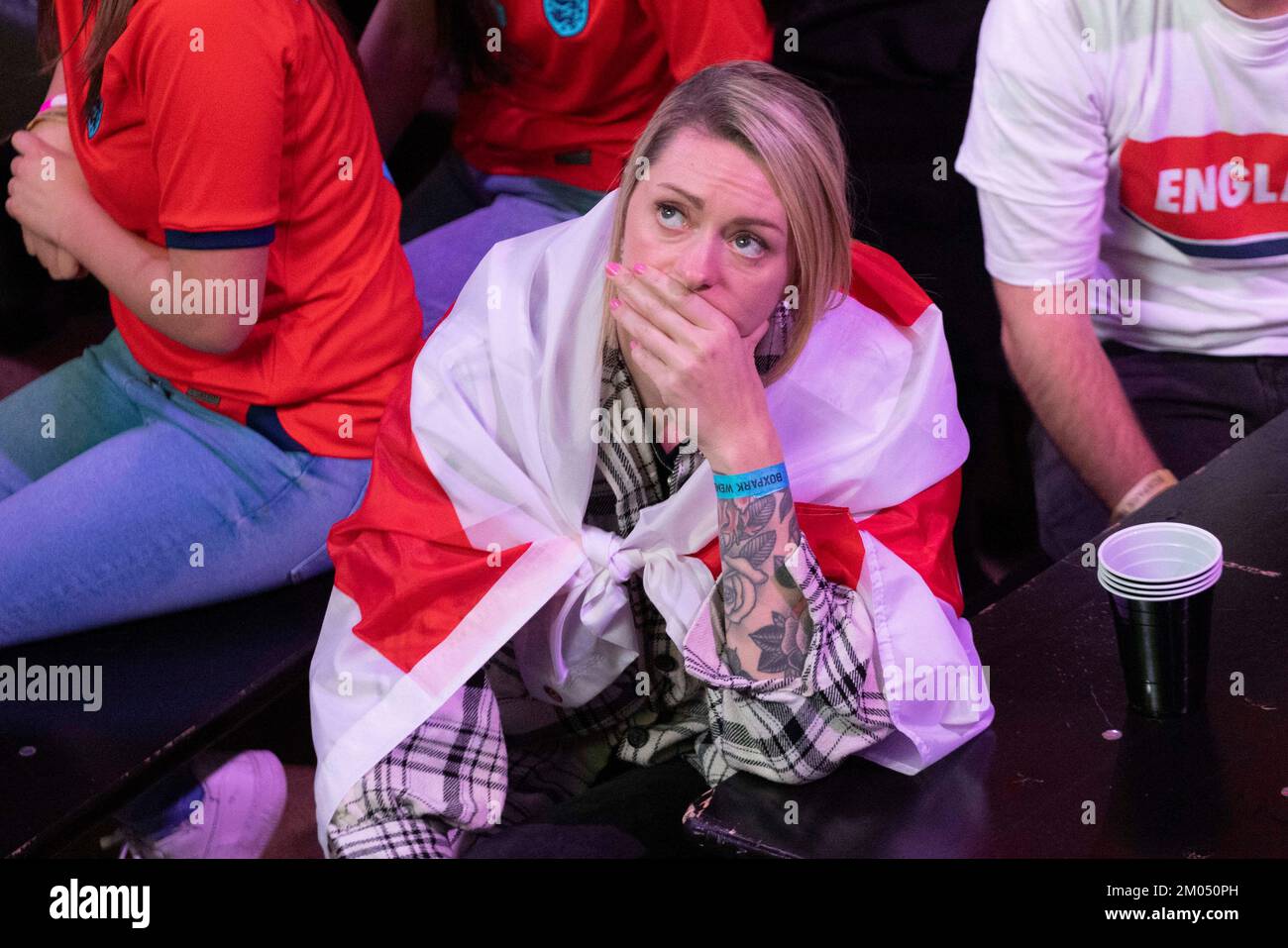 Englische Fußballfans sehen heute Abend das Fußballweltmeisterschaftsspiel zwischen England und den USA im Boxpark, Wembley in London. Fans scheinen frustriert und enttäuscht zu sein Stockfoto