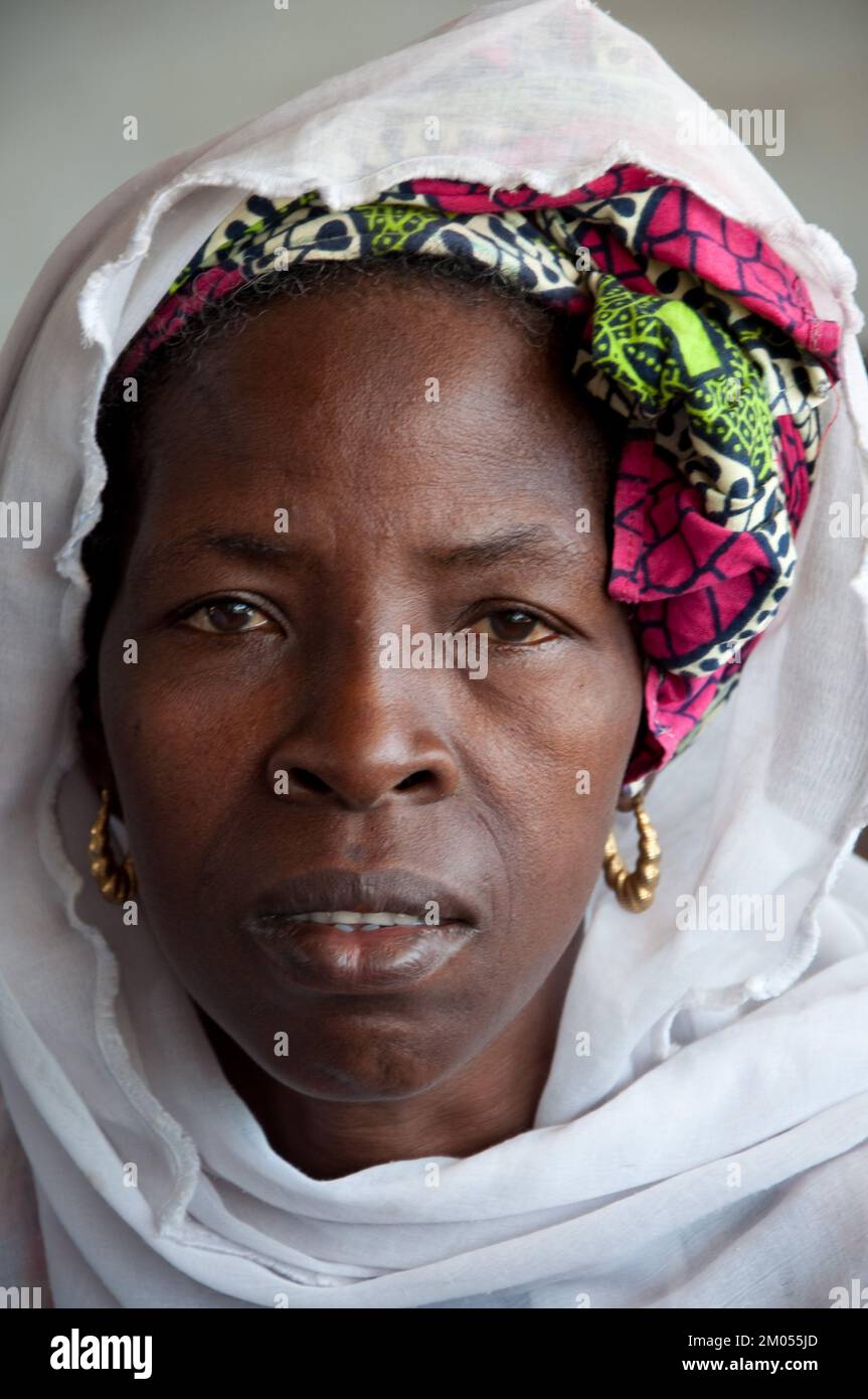 Gesichter Afrikas, Afrikanerin, Bafata, Guinea-Bissau - ängstliche Ausdrucksform; schönes Kopfkleid; goldene Ohrringe; Stockfoto